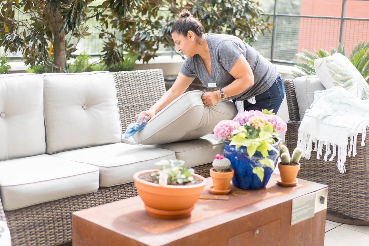 HPH employee cleaning patio furniture in the Woodlands